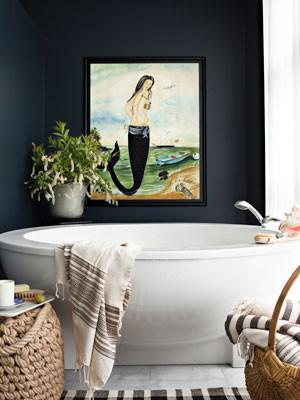 Белая круглая ванна, темно-серая стена и картина в маленькой ванной